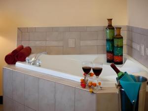 a bath tub with two glasses of wine and wine bottles at Magnuson Grand Conference Hotel in Cypress Gardens +38 photos