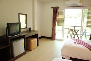 a bedroom with a bed and a television on a desk at Sukthavorn Residence in Ban Pa Tung (7)