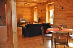 a living room with a black couch and a table at Alevi Holiday Home with Sauna in Tallinn