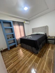 a bedroom with a bed and a wooden floor at Canari Apartamento in Comayagüela