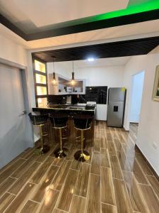 a kitchen with a bar with stools in a room at Canari Apartamento in Comayagüela