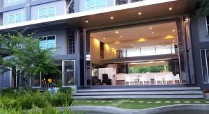 a house with a large glass door with a patio at A+ Hotel in Ban Na Khwai