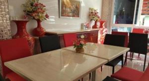 a dining room with a table and red chairs at V-House Hotel in Trang +15 photos