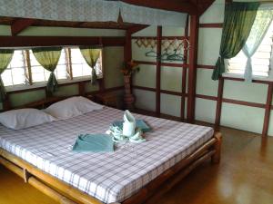 a bedroom with a bed with towels on it at Casa de la Playa Beach Resort in Siquijor +105 photos