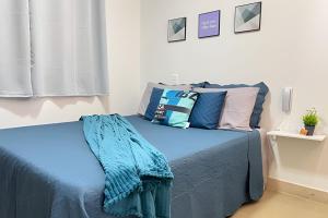 a bedroom with a bed with blue sheets and pillows at Studio c Piscina e Academia a 13 min de Copa. in Rio de Janeiro +236 photos