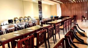 a row of tables and chairs in a restaurant at Grand Metro Hotel Tasikmalaya in Tasikmalaya