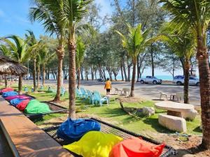 a row of tents on the grass with palm trees at The Bed Vacation Rajamangala Hotel in Songkhla