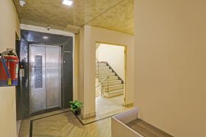 a hallway with a door and stairs in a house at Hotel O Raas Near Hira Sweet in New Delhi