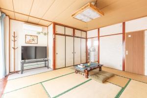 a living room with a television and a table at 観光名勝千畳敷徒歩2分 shirahamaペンション千畳嵐 