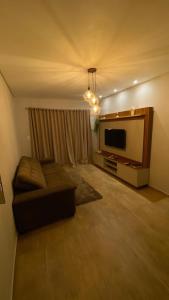 a living room with a couch and a flat screen tv at Casa da Gih in Penha