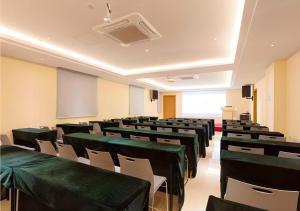 an empty lecture room with green tables and chairs at JTOUR Inn Guigang Life Port High-speed Railway Station in Guigang