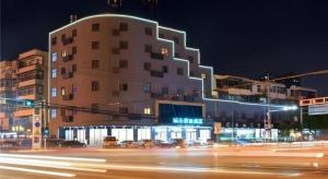 a building on a city street at night at City Comfort Inn Wuhan Huangpi Xiangyang Avenue Panlong in Wuhan