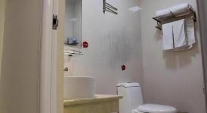 une salle de bain blanche avec toilettes et lavabo dans l'établissement Thank Inn Hotel Hebei Xingtai Shaheweisan Road Expressway Intersection, à Shahecheng