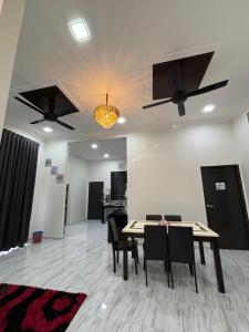a dining room with two ceiling fans and a table at D Bukit homestay in Ketereh