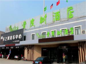 a building with a car parked in front of it at Vatica Tianjin Dagang Xuefu Road University Town Hotel in Binhai