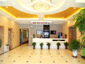 a lobby with potted plants in a building at Vatica Tianjin Dagang Xuefu Road University Town Hotel in Binhai
