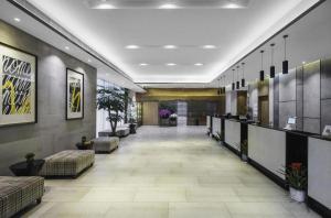 a lobby with couches and tables in a building at Campanile Hotel Dongying Financial Port in Dongying