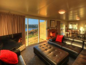 a living room with a couch and a fireplace at Arthur River Spa Cottage in Arthur River