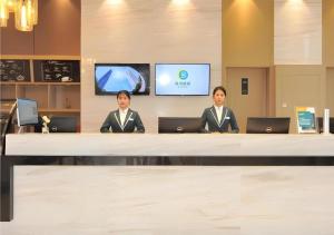 two women in suits sitting at a table with laptops at City Comfort Inn Chengdu Transportation Technical College Traditional Chinese Medicine in Chengdu