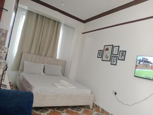 モンバサにあるVITU FINE Homes 1のベッドとテレビのある白い部屋