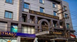 a building with a sign on the side of it at Hotel Grand Millennium in Lahore