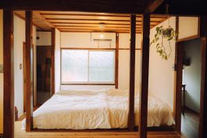 Futamiにある海とふれあうための一軒貸し宿オリーブの窓のある部屋のベッド
