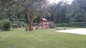 a park with a playground with a slide and benches at Ferienwohnung Christian am Ossiachersee in Bodensdorf