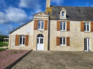 ein altes Steinhaus mit einer großen Auffahrt in der Unterkunft lefevre cottage, Landing beaches house in Saint-Pierre-du-Mont
