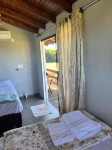 a room with a bed and a sliding glass door at Quarto 4 Aventureiro in Santa Rosa +2 photos