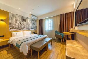 a hotel room with a large bed and a chair at City Comfort Inn Wuhan Changfeng Avenue 3rd Hanxi Road in Wuhan