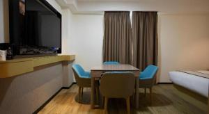 a hotel room with a table and chairs and a bed at City Comfort Inn Huaihua East Station in Huaihua