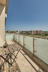 a balcony with a wooden chair on top of a building at Konstanzer 103 - 2 Room Ap & Parking- Iulius Mal - Smart TV - Highspeed Wi-Fi in Iaşi