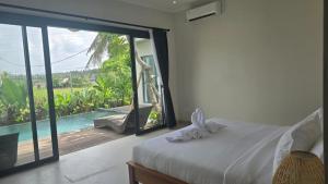 Un dormitorio con una cama y vistas a una piscina. en Adyatma Ubud, en Ubud