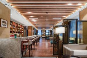 Un vestíbulo con un bar y una fila de taburetes. en Tanshan Hotel, en Shangri-La