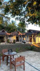a table and a bench in front of a house at A-Thip House in Pai