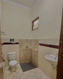 une salle de bain avec toilettes et lavabo dans l'établissement Hotel New Pesona Anggraini, à Brujul