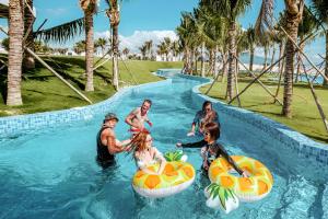 a group of people in a pool at a resort at The Light Arena Ocean Tower in Cam Ranh International Airport