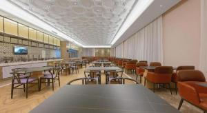 a cafeteria with tables and chairs in a room at Vienna Hotel Qinghai Dachaidan in Da Qaidam