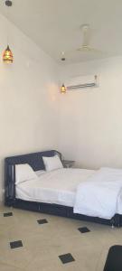 - une chambre avec deux lits blancs et deux lumières dans l'établissement Pearl Pride Villa Udaipur, à Udaipur