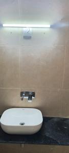 La salle de bains est pourvue d'un lavabo blanc sur un mur. dans l'établissement Pearl Pride Villa Udaipur, à Udaipur