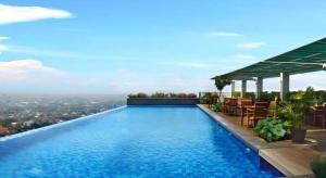 a swimming pool on top of a building at Horison Ultima Semarang in Jomblang