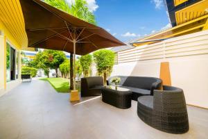 un patio avec deux chaises et un parasol dans l'établissement Mediteranean style 3 BR Pool Villa Platinum with garden, à Rawai Beach
