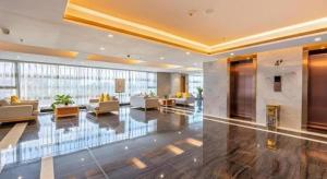 a lobby with couches and chairs in a building at Green Tree Inn Zhuhai International Airport Huafa Shangdu in Baigaonongchang +229 photos