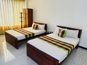 Dos camas sentadas en una habitación con en Hotel Winrose Tissamaharama, en Tissamaharama