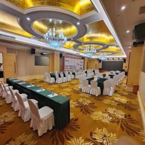 a banquet hall with white chairs and tables in a room at SHANGJINGHAO HOTEL （SAKATA SNOW ELEPHANT SUBWAY STATION SHOP） in Tiantangwei