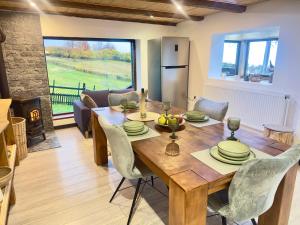 a kitchen and dining room with a wooden table and chairs at Cabana Mia Parang in Petroşani