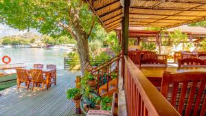 a wooden deck with a table and chairs and a boat at Dalyan Pension in Dalyan