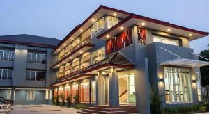 a large building with red doors and windows at Soontree House Hotel in Udon Thani