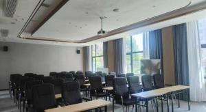 a room with chairs and tables and a large window at Echarm Hotel Zhuzhou Liling in Li-ling-hsien