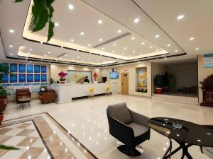 a lobby with a chair and a table and a counter at GreenTree Inn Express Wuxi Jiangyin Wanda Plaza Tongfu Road in Jiangyin